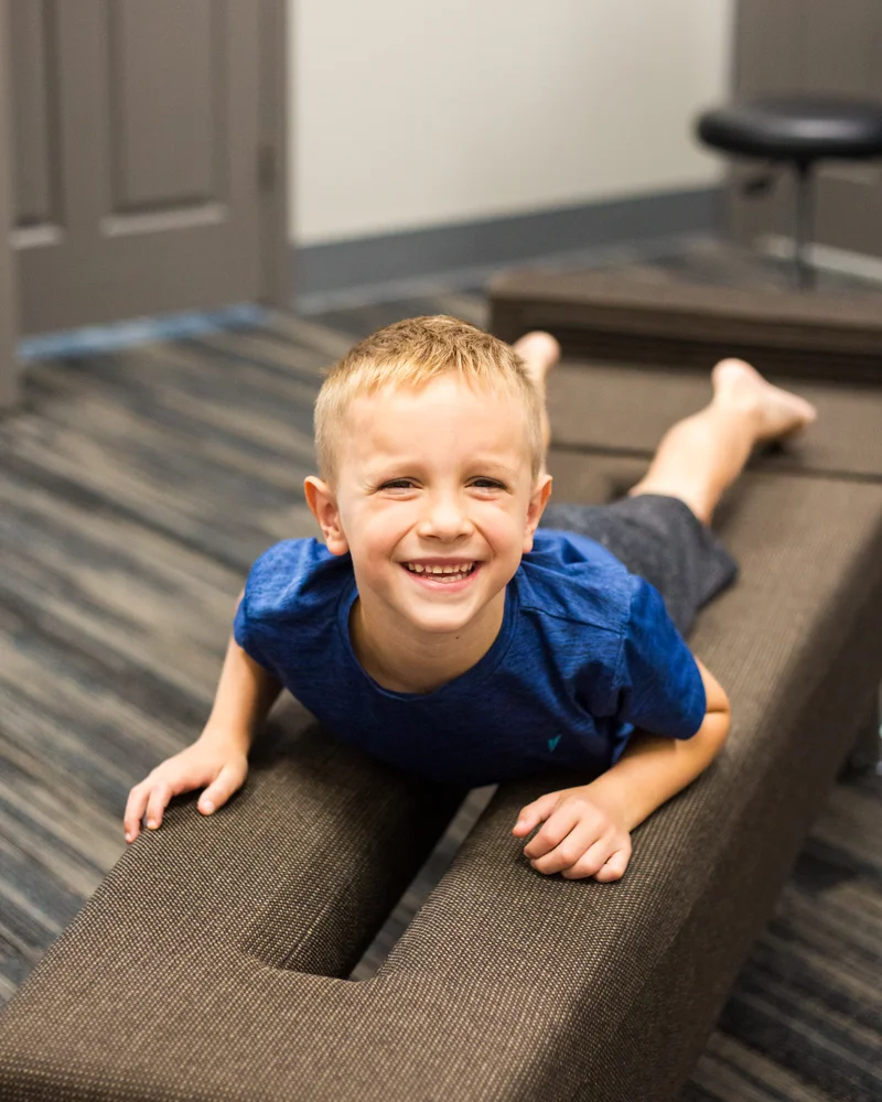 A young patient lying on the adjusting table at Full Circle Health