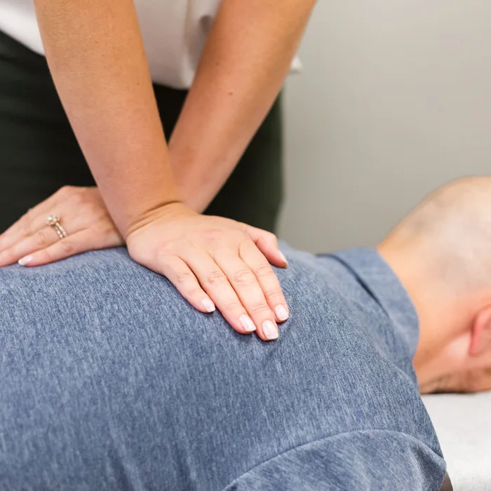 Dr. Noonan working along a patient’s upper back and shoulders