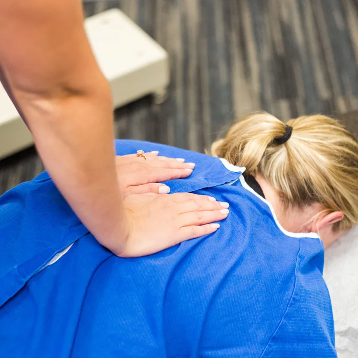 Hands-on treatment at the base of the neck and upper back