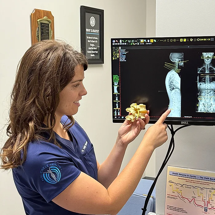 Dr. Noonan reviewing a patient’s spinal X-rays on screen at Full Circle Health