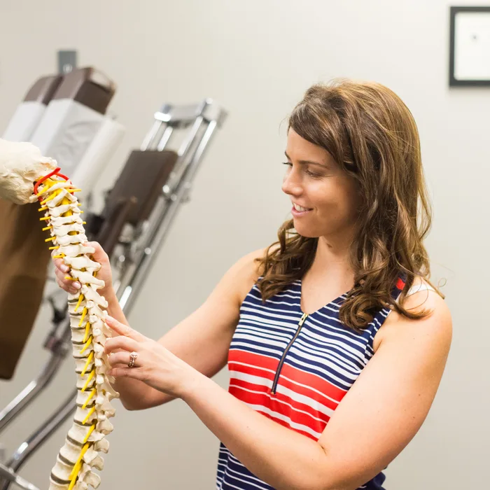 Dr. Noonan holding a spine model to explain the source of shoulder pain